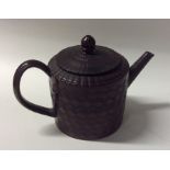 A small terracotta glazed teapot with incised wave