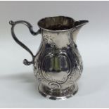 A George II embossed silver pitcher cream jug deco