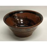A tub shaped pottery bowl of tenmoku design. Signe