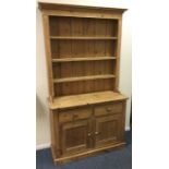 A stripped pine two door dresser with shaped edge.