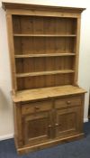 A stripped pine two door dresser with shaped edge.