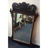 An Antique mahogany mirror with carved shaped top.