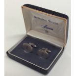 A pair of silver cufflinks with engine turned deco