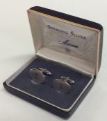 A pair of silver cufflinks with engine turned deco