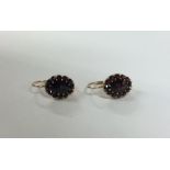 A pair of garnet mounted cluster earrings in claw