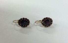 A pair of garnet mounted cluster earrings in claw