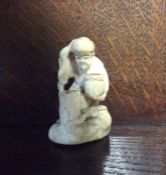 A small carved ivory netsuke of an Oriental man. E