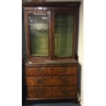 A good walnut veneered bookcase on bracket feet wi