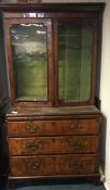 A good walnut veneered bookcase on bracket feet wi