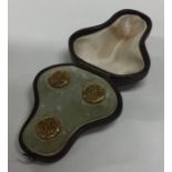 A cased set of three gold studs. Approx. 3.3 grams