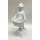 A Continental porcelain figure of a child holding