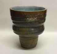 A top heavy drip glazed stoneware pottery vase on