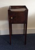 A Georgian mahogany bedside cabinet on tapering le