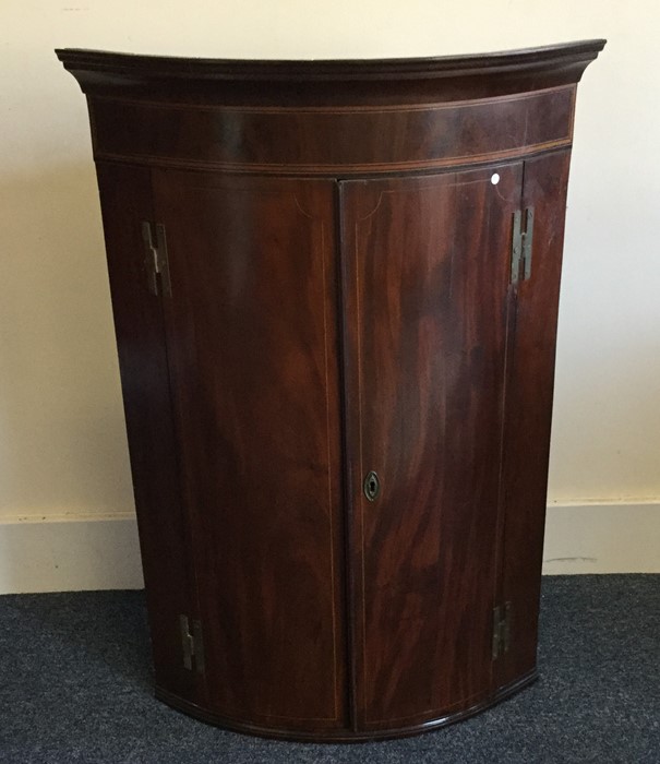 A Georgian mahogany bow front corner cabinet. Est.