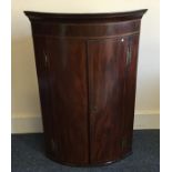 A Georgian mahogany bow front corner cabinet. Est.