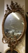 A circular gilt wall mirror with floral decoration