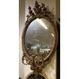 A circular gilt wall mirror with floral decoration