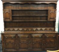 A massive oak four drawer and four door dresser wi