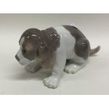 A Lladro fire of a seated subdued puppy. Est. £10