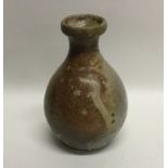 A small stoneware baluster shaped vase of drip gla