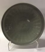 A circular shallow Chinese glazed celadon dish of