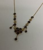 A garnet and pearl necklet on gold fine link chain