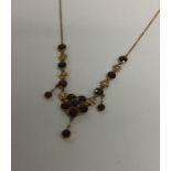 A garnet and pearl necklet on gold fine link chain