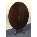 A late Victorian oval top table with scroll inlay.