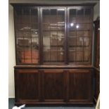 A large mahogany three door bookcase with moulded