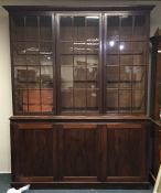 A large mahogany three door bookcase with moulded