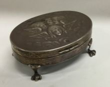 An oval silver jewellery box decorated with winged