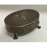 An oval silver jewellery box decorated with winged