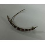 A ruby and diamond crescent brooch in gold mount.