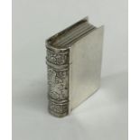 A silver pill box in the form of a book with engra