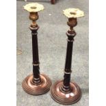 A pair of tall mahogany tapering candlesticks. Est