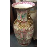 A tall Chinese vase decorated in bright colours wi