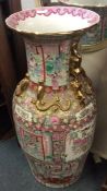 A tall Chinese vase decorated in bright colours wi