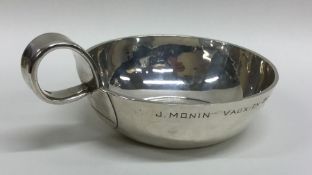 A large plain silver wine taster of circular form