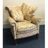 A Victorian upholstered armchair on tapering suppo