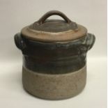 A partially glazed stoneware pottery cannister / l