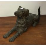 A cast iron figure of a seated dog with textured b