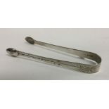 A pair of George III silver sugar tongs with brigh