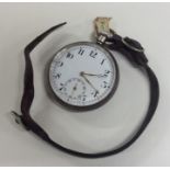 A silver open faced pocket watch with leather stra