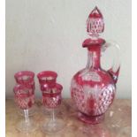 An attractive cranberry glass liqueur set comprisi
