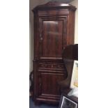 A large flame mahogany corner cupboard with single