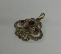 A stylish amethyst and pearl pendant with loop top