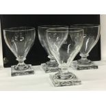 A set of four Georgian style wine glasses on squar