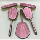 A five piece silver and pink enamelled dressing ta