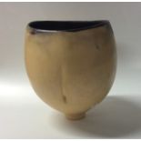 A bulbous shaped pottery footed bowl / vase in yel