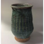 BUCKFAST ABBEY: A baluster shaped green glazed vas